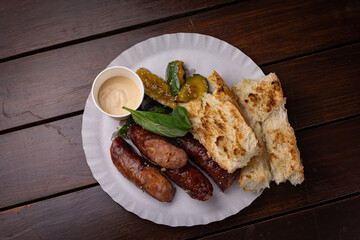 appetizing grilled sausages with sauce and bread