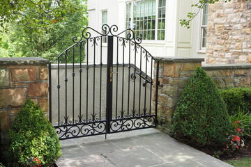 The black wrought iron gate acts as security or the property.