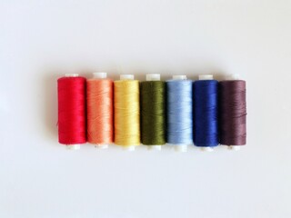 Coils of thread in rainbow color on a white background. Top view