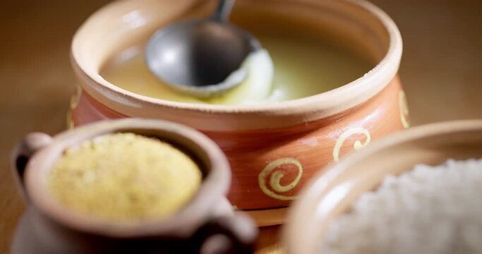 Basmati rice, spices and ghee on a wooden table.