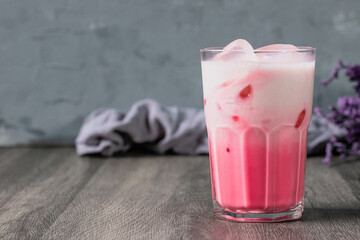 cold pink milk cold drink in clear glass on gray background. Thai milk