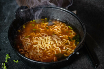 Spicy Korean Instant Noodles with Wakame Seaweed in a Black Iron Pot, Korean Food Traditional Style