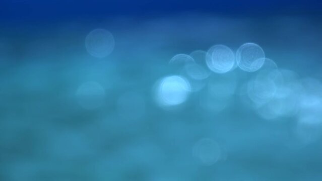 Defocused blue pool water surface glittering bokeh as abstract background