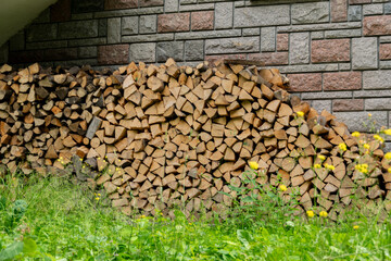 Pilewood for fire on the exterior wall of the house