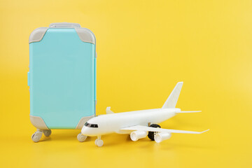 airplane and luggage suitcase on yellow background,travel and tourism