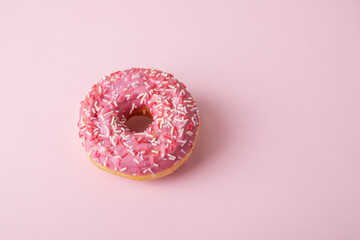 Fototapeta na wymiar pink glazed donut with confectionery sprinkles