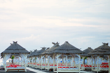 hotel beach with bungalows for rest and relaxation at sunset
