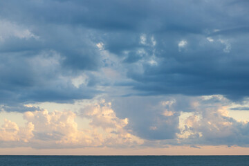 Naklejka na ściany i meble cloudy sky on the sea in sunlight,clouds background at sunset
