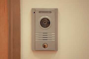 Video intercom system on white wall to enter office. Intercum with a camera in the office. New video intercom. Video intercom display on white wall near the entrance door