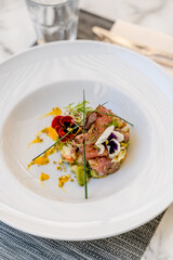 Un plat coloré avec du saumon, une fleur et de la ciboulette