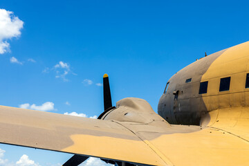 Old Military Plane From Second World War Close Up detail With Blue Sky and White Clouds in the Background