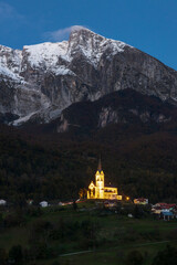 Fototapeta na wymiar Basilic of Dreznica Under mount Krn illuminated in Evening Hours - Kobarid, Slovenia