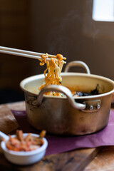 Instant noodles in chopstick over aluminum pot