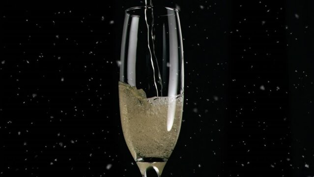 Animation of white spots over glass of champagne on black background