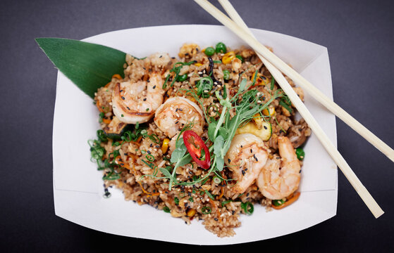 Fried rice with seafood and vegetables prepared in wok as vegetarian street food concept. Shrimps, squid and octopus with rice stir fry. High quality image