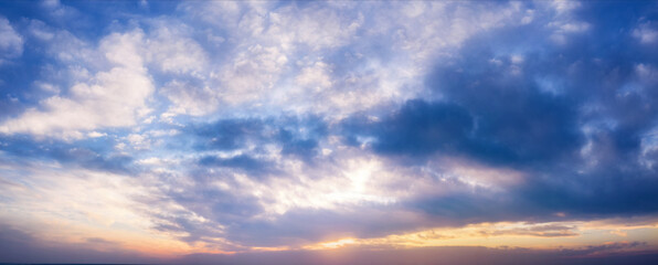 Naklejka na ściany i meble Beautiful sunset sky with clouds and bright sunlight. Background.