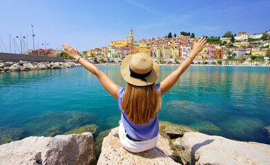 Traveling in France. Panoramic view of traveler girl with arms raised enjoying view of Menton...