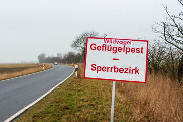Warnschild Geflügelpest an einer Landstraße in Norddeutschland