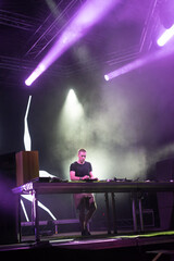 Dj playing techno music on the night concert in summer