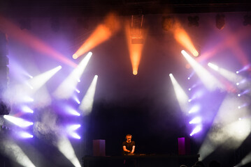 Dj playing techno music on the night concert in summer