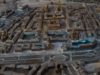 View of a small replica of the Lviv town. Miniature model of old town district of Lviv made of metal and installed in the Market Square. Selective focus. Bronze Buildings and Churches. 
