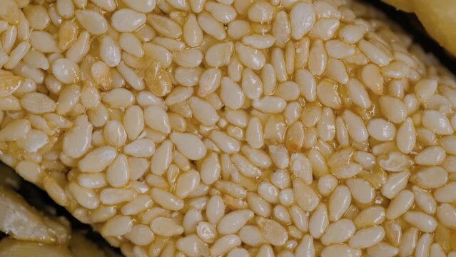 Top view: honey granola sesame seed bar - Gozinaki on rotating surface - close up. Traditional Georgian cuisine, oriental sweet, gastronomy and food concept