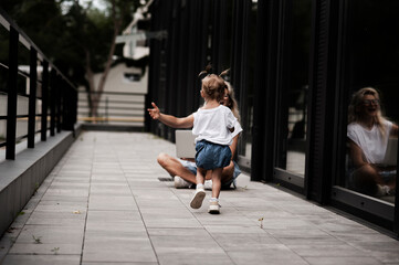 A girl with a child on maternity leave, walking with a child and working with a laptop.Works in a comfortable place, enjoys it. The concept of freelancing and working for fun