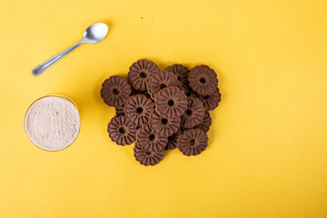 Bolacha biscoito de chocolate caseiro na forma de flor isolado em fundo amarelo