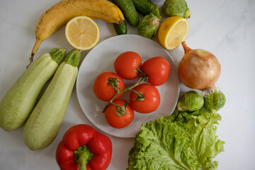 Plate of different vegetables and fruits on a light background