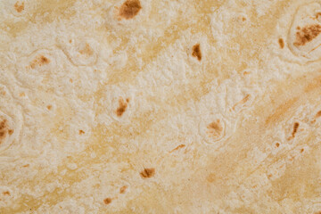 Plain wheat tortilla wraps. Spanish or Mexican circular unleavened flatbread from wheat flour. Ingredient for cooking fast food or snack. Closeup, texture background