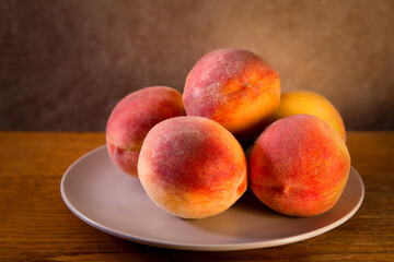 Fototapeta na wymiar ripe peaches on a beige plate