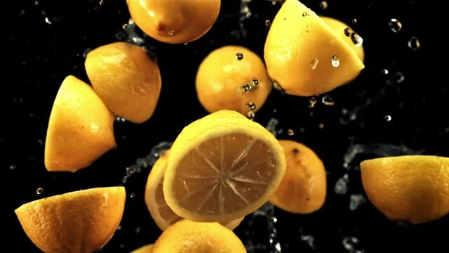 Lemon halves fly up and rotate in flight. On a black background. Filmed is slow motion 1000 fps.