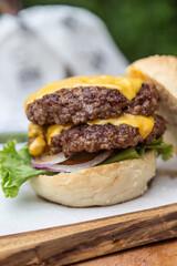 Double cheeseburger with onions, tomato, lettuce and cheddar cheese