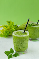 green smoothie with celery.healthy smoothie with organic ingredients, with green vegetables on the green background. Raw, vegan, vegetarian, detox food and drink. copy space