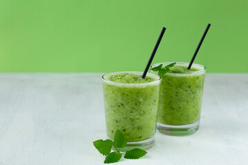 smoothie with mint.vegetarian concept. Green healthy smoothie with organic ingredients, with green vegetables on the green background. Raw, vegan, vegetarian, detox food and drink. copy space