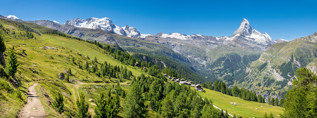 The panorama of swiss walliser alps with the Matterhorn and Breithorn peaks over the Zermatt in Mattertal valley.