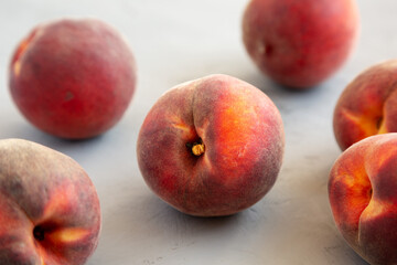 Raw Organic Yellow Peaches on a gray background, side view.