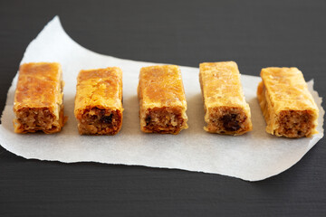 Homemade Baklavas with Honey, Chocolate and Almond on a black background, side view. Close-up.