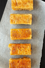 Homemade Baklavas with Honey, Chocolate and Almond on a black background, top view. Flat lay, overhead, from above.
