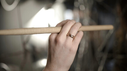 Close-up of hand with drumstick. Action. Female hand professional drummer holds wooden drumstick...