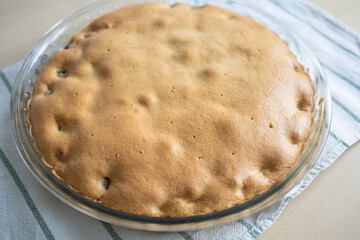 homemade cakes, a pie in a glass plate, on a towel. Baking for tea, warm welcome, home cooking. Rapid weight gain, carbohydrates, sweets