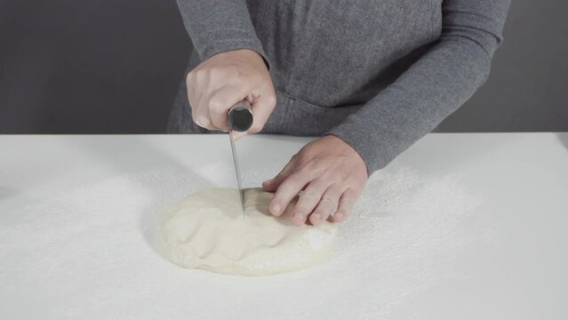 Rolling bread dough with a french rolling pin to make homemade flatbread.