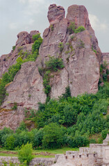 Fototapeta na wymiar This place called Belogradchic Rocks is in Bulgaria. Centuries old rock look like figures or appear like characters . Climb the stairs to the top or look at the gatehouse of the old fortress.