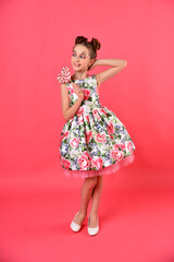 A cute girl with balloons and candy. Pink background. Party.