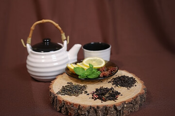 three types of tea leaves are laid out, there is a teapot and a cup nearby. High quality photo