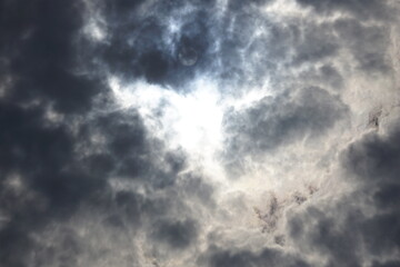 Faint sun trying to peek through dark clouds
