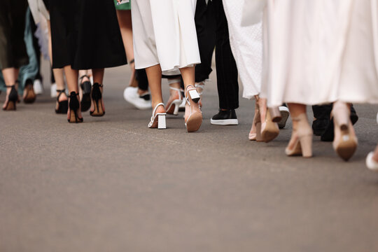 the feet of the group of people are walking outdoors. graduation day. stylish young guys and girls in stylish shoes.