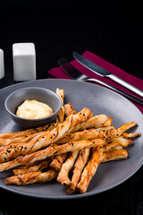 Breadsticks with cheese delicious snack. Grissini with cheese on a gray plate