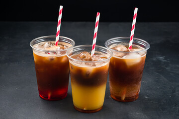 Various iced layered coffee drinks with orange juice and syrups