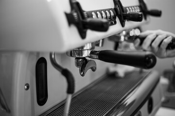 Barista holds a holder and makes coffee with a double-boiler coffee machine